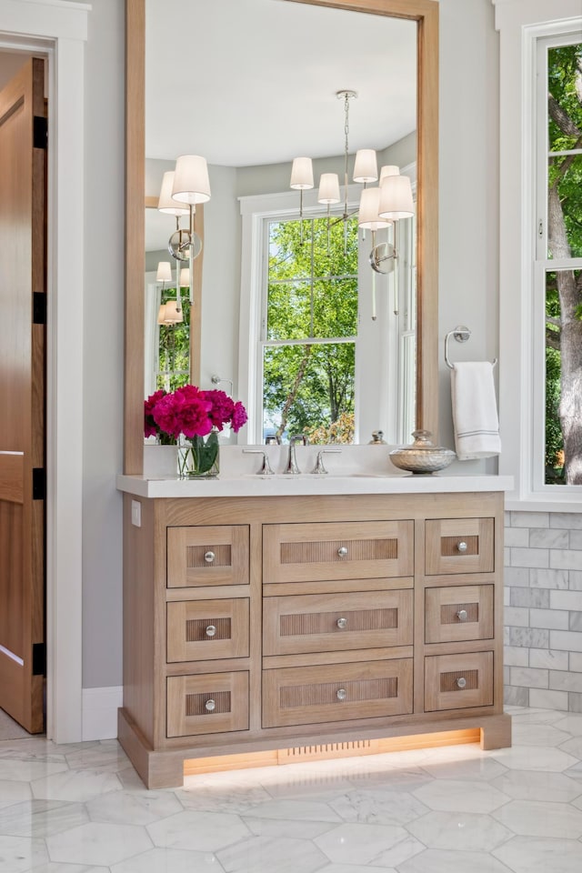2475 Dunwoody Ave, Orono, MN 55391 - bar featuring healthy amount of natural light, light marble finish flooring, a chandelier, and pendant lighting