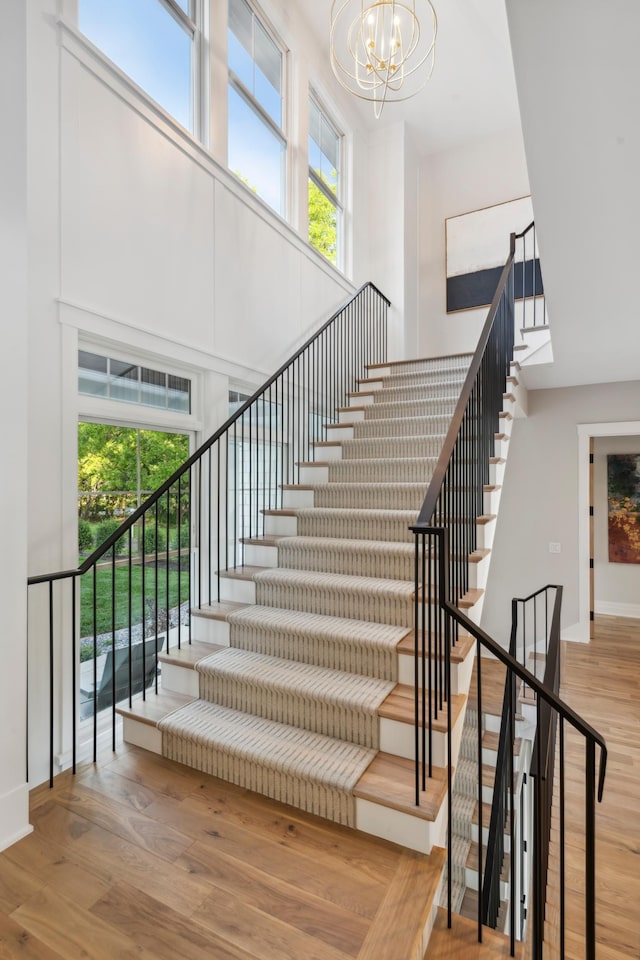 2475 Dunwoody Ave, Orono, MN 55391 - staircase featuring a high ceiling, a chandelier, wood finished floors, and baseboards