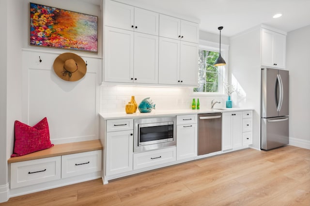 2475 Dunwoody Ave, Orono, MN 55391 - kitchen featuring stainless steel appliances, white cabinetry, backsplash, decorative light fixtures, and recessed lighting