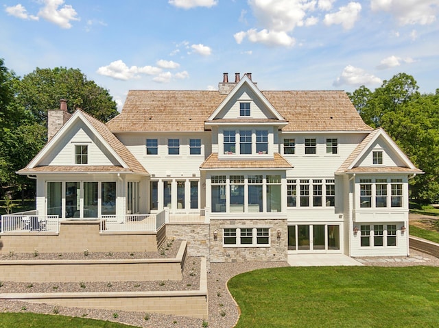 2475 Dunwoody Ave, Orono, MN 55391 - rear view of house with a sunroom, a chimney, a patio, and a yard