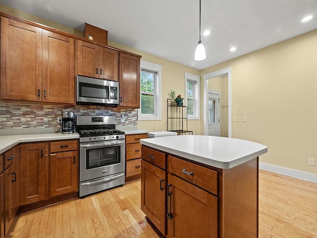 2727 3rd St, Minneapolis, MN 55411 - kitchen featuring appliances with stainless steel finishes, light wood finished floors, backsplash, and recessed lighting