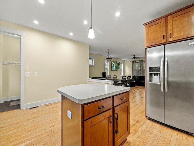 2727 3rd St, Minneapolis, MN 55411 - kitchen featuring stainless steel refrigerator with ice dispenser, light wood-style floors, a kitchen island, recessed lighting, and brown cabinetry