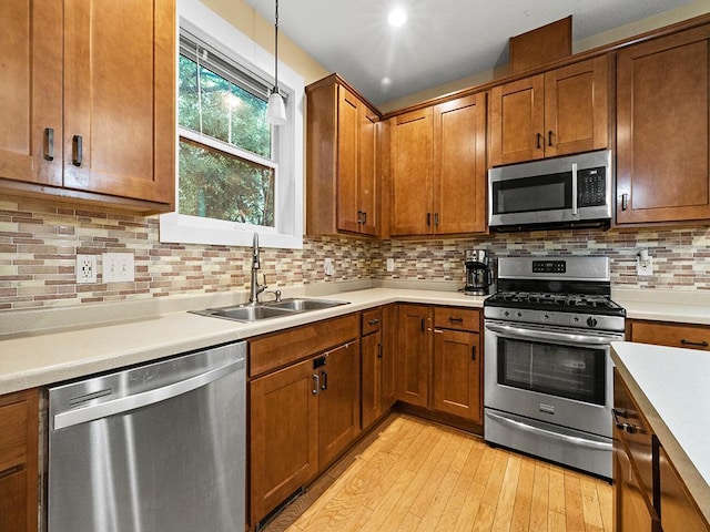 2727 3rd St, Minneapolis, MN 55411 - kitchen with appliances with stainless steel finishes, brown cabinets, hanging light fixtures, and light countertops