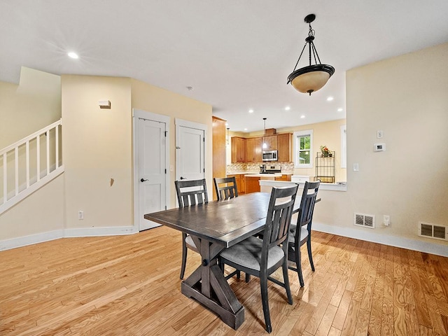 2727 3rd St, Minneapolis, MN 55411 - dining space featuring stairway, light wood-type flooring, and recessed lighting