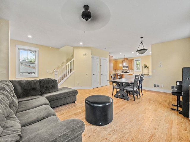2727 3rd St, Minneapolis, MN 55411 - living room with plenty of natural light, light wood-type flooring, ceiling fan, recessed lighting, and stairway