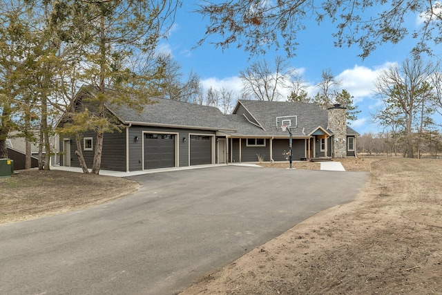 10267 Ferry Point Pl NW, Watab Twp, MN 56367 - view of front of home featuring an attached garage, driveway, a chimney, and a shingled roof