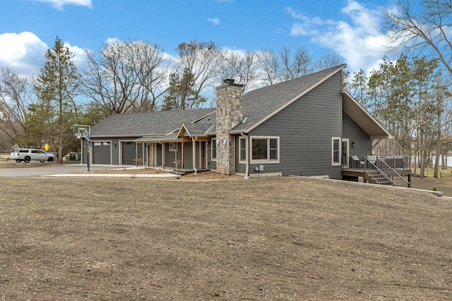10267 Ferry Point Pl NW, Watab Twp, MN 56367 - back of house with driveway, a garage, a chimney, roof with shingles, and stairway