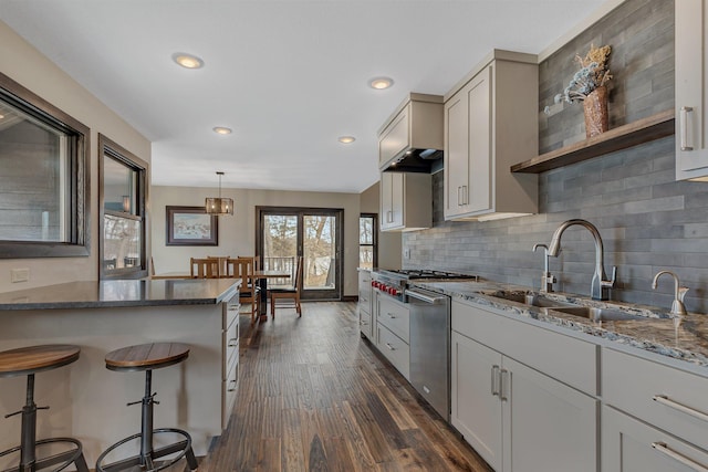 10267 Ferry Point Pl NW, Watab Twp, MN 56367 - kitchen with a sink, appliances with stainless steel finishes, dark stone countertops, a kitchen breakfast bar, and dark wood finished floors