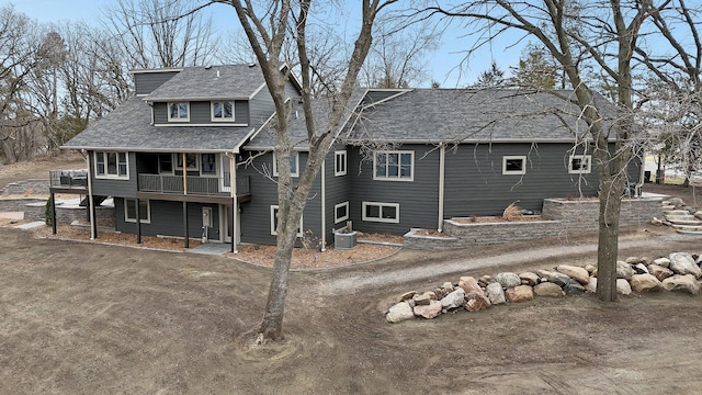 10267 Ferry Point Pl NW, Watab Twp, MN 56367 - rear view of house with a balcony, a shingled roof, central air condition unit, and dirt driveway