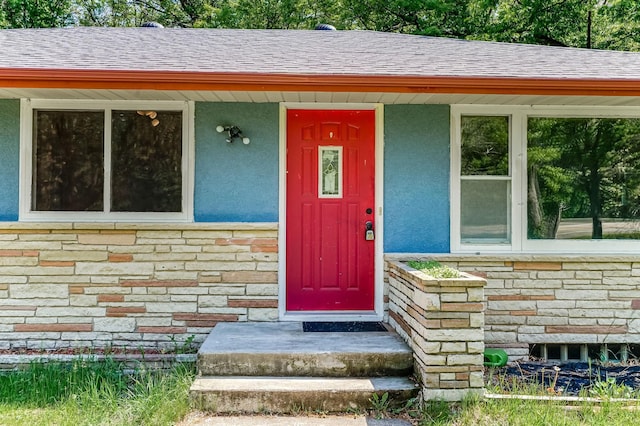 20257 Viking Blvd NE, Wyoming, MN 55092 - view of exterior entry featuring stucco siding, stone siding, and a shingled roof