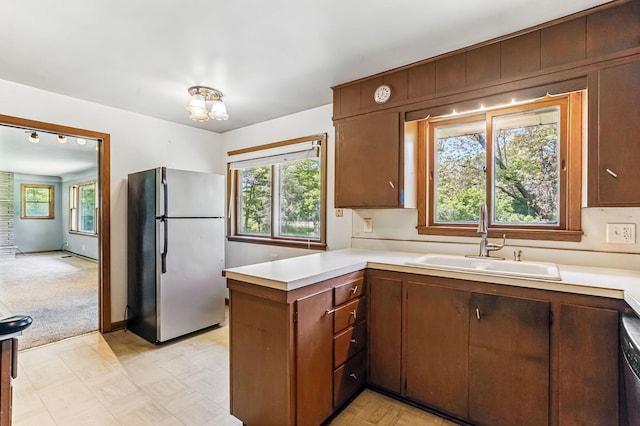 20257 Viking Blvd NE, Wyoming, MN 55092 - kitchen featuring freestanding refrigerator, a sink, a peninsula, light countertops, and plenty of natural light