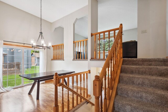 11813 Kerry St NW, Coon Rapids, MN 55433 - stairway featuring a chandelier, wood finished floors, and high vaulted ceiling