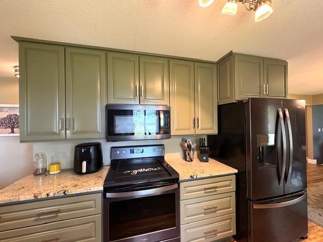 208 Mason Ave, Verndale, MN 56481 - kitchen with appliances with stainless steel finishes, green cabinets, light stone counters, and a textured ceiling