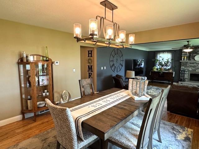 208 Mason Ave, Verndale, MN 56481 - dining area with a chandelier, wood finished floors, a ceiling fan, and baseboards