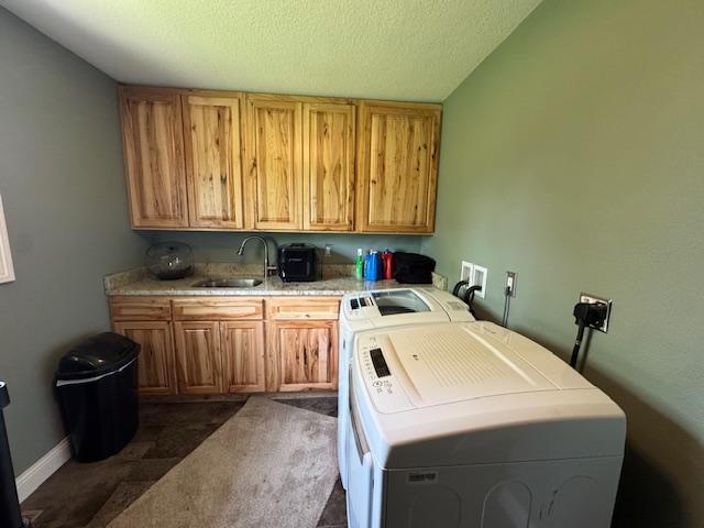 208 Mason Ave, Verndale, MN 56481 - laundry room featuring cabinet space, washing machine and clothes dryer, dark colored carpet, baseboards, and a textured ceiling