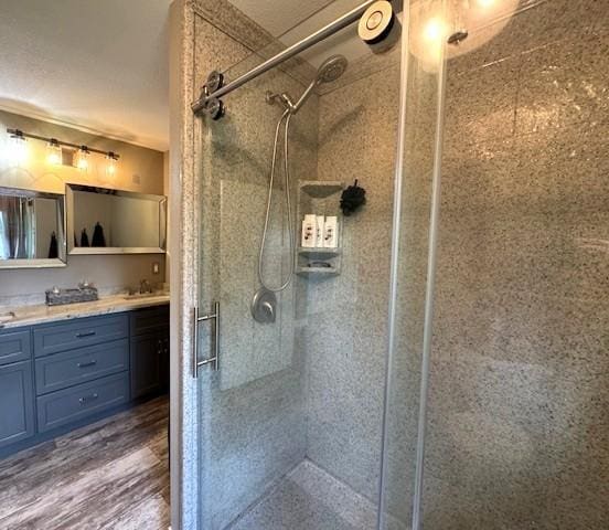 208 Mason Ave, Verndale, MN 56481 - full bath featuring a stall shower, double vanity, and wood finished floors