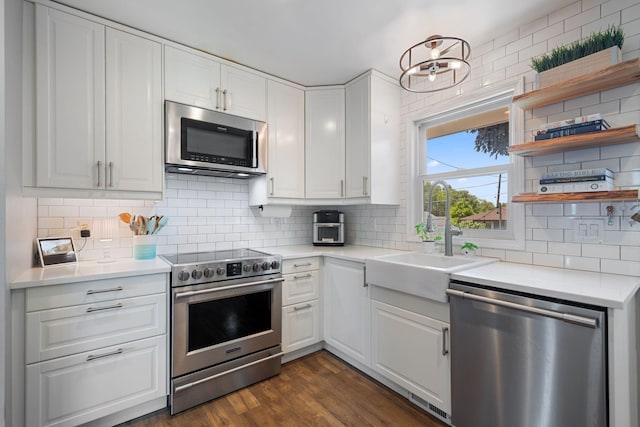 3646 Buchanan St NE, Minneapolis, MN 55418 - kitchen with appliances with stainless steel finishes, a sink, decorative backsplash, white cabinetry, and light countertops