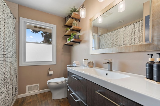 3646 Buchanan St NE, Minneapolis, MN 55418 - bathroom featuring wood finished floors, vanity, toilet, baseboards, and a shower with curtain