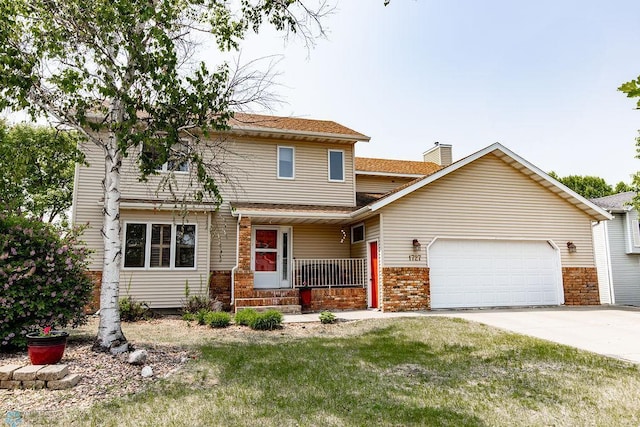1727 33rd St S, Moorhead, MN 56560 - view of front of home with covered porch, an attached garage, concrete driveway, brick siding, and a shingled roof