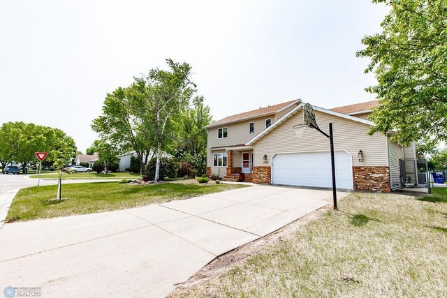 1727 33rd St S, Moorhead, MN 56560 - view of front of house featuring an attached garage, a front lawn, concrete driveway, and brick siding