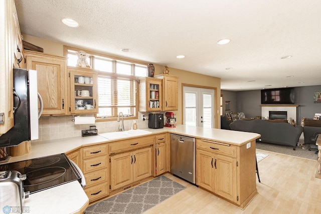 1727 33rd St S, Moorhead, MN 56560 - kitchen with dishwasher, a sink, a peninsula, light countertops, and a tile fireplace