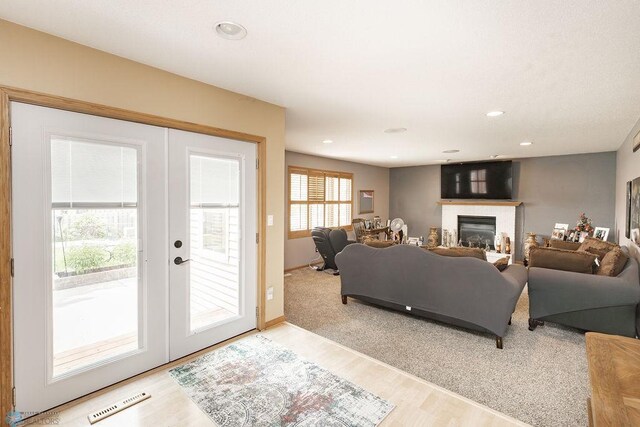 1727 33rd St S, Moorhead, MN 56560 - living room featuring light wood-style flooring, french doors, a glass covered fireplace, recessed lighting, and baseboards