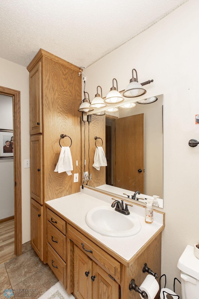 1727 33rd St S, Moorhead, MN 56560 - half bath with vanity, toilet, and a textured ceiling
