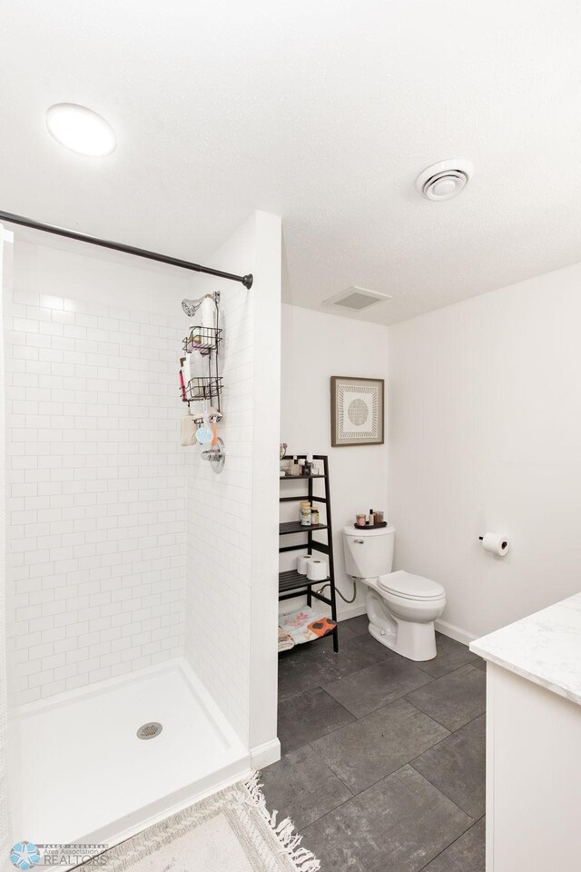 1727 33rd St S, Moorhead, MN 56560 - full bathroom featuring vanity, a tile shower, toilet, and baseboards
