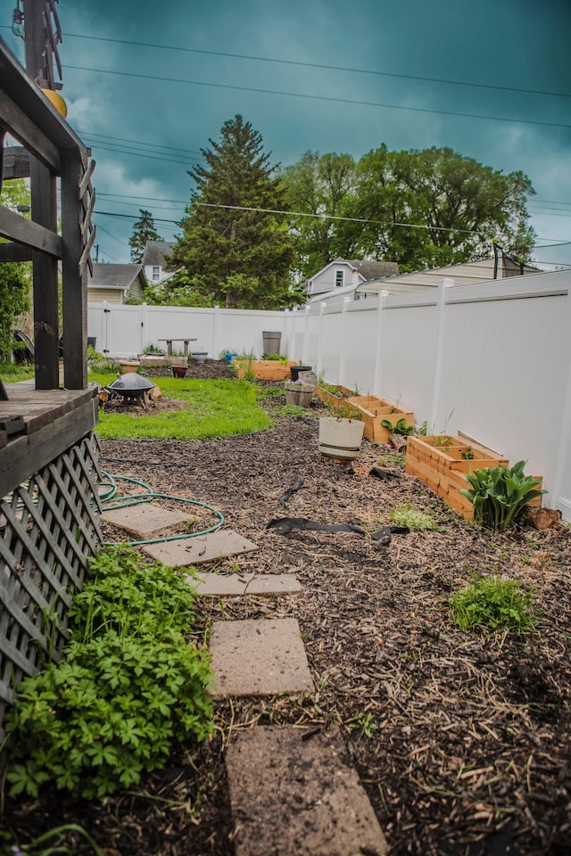 210 6th St, Morris, MN 56267 - fenced backyard featuring a garden and an outdoor fire pit