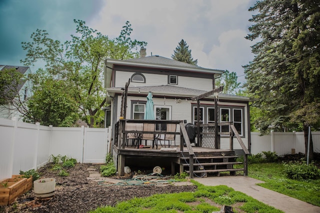210 6th St, Morris, MN 56267 - rear view of house featuring a wooden deck, a fenced backyard, and a chimney