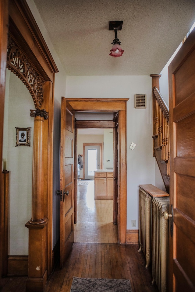 210 6th St, Morris, MN 56267 - hallway with dark wood-style flooring, baseboards, a textured ceiling, and stairs