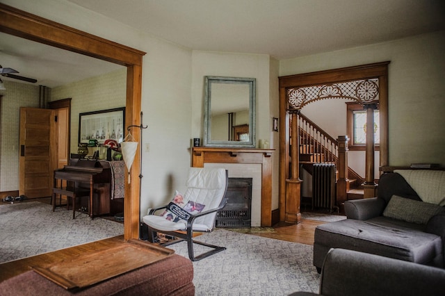 210 6th St, Morris, MN 56267 - living room with stairs, a fireplace, wood finished floors, radiator, and ceiling fan