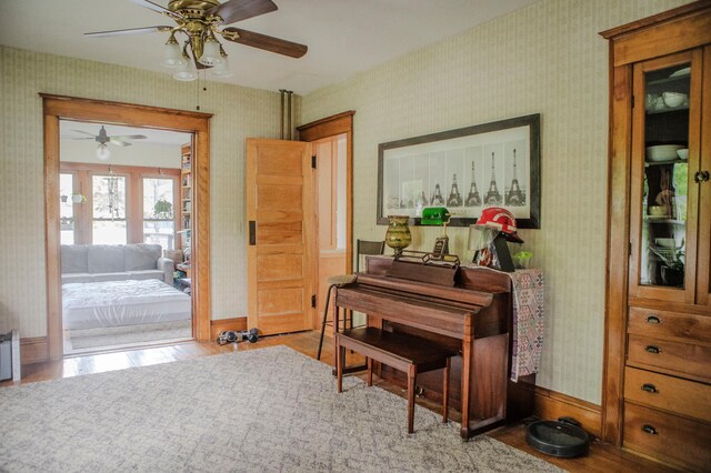 210 6th St, Morris, MN 56267 - living area with wallpapered walls, a ceiling fan, wood finished floors, and baseboards