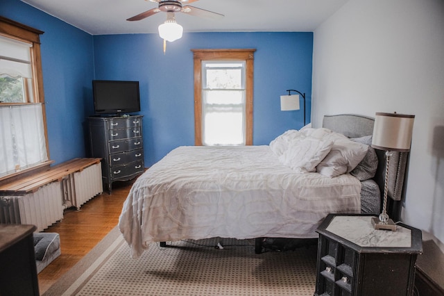 210 6th St, Morris, MN 56267 - bedroom featuring wood finished floors, radiator heating unit, and ceiling fan