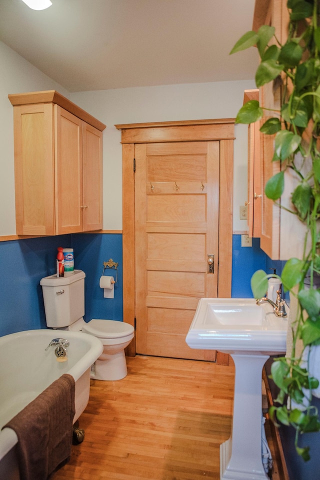 210 6th St, Morris, MN 56267 - full bathroom featuring a freestanding tub, wood finished floors, and toilet