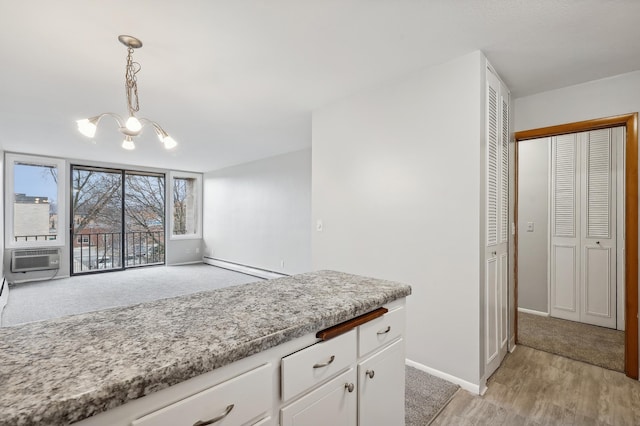 4029 14th Ave S Unit 14G, Minneapolis, MN 55407 - kitchen featuring a baseboard heating unit, a chandelier, white cabinetry, baseboards, and hanging light fixtures