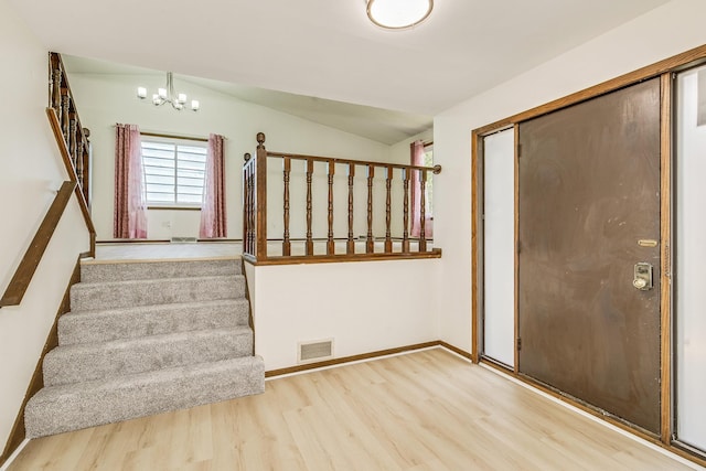 2723 Innsbruck Dr, New Brighton, MN 55112 - entrance foyer with wood finished floors, stairway, vaulted ceiling, a chandelier, and baseboards