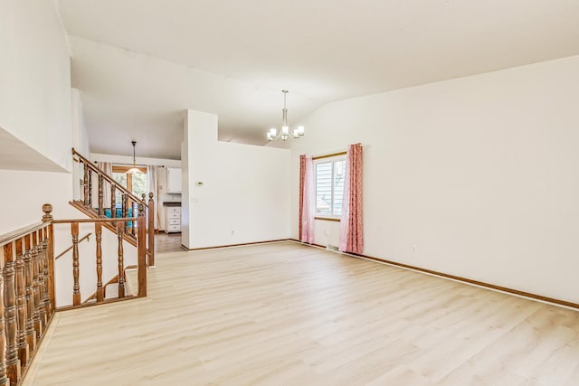 2723 Innsbruck Dr, New Brighton, MN 55112 - unfurnished room with light wood-type flooring, vaulted ceiling, a chandelier, stairway, and baseboards