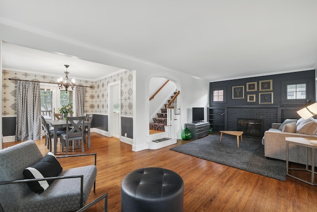 4848 Ewing Ave S, Minneapolis, MN 55410 - living area featuring wallpapered walls, a chandelier, crown molding, stairs, and wood finished floors