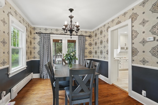4848 Ewing Ave S, Minneapolis, MN 55410 - dining space with a baseboard radiator, a chandelier, wallpapered walls, wood finished floors, and crown molding