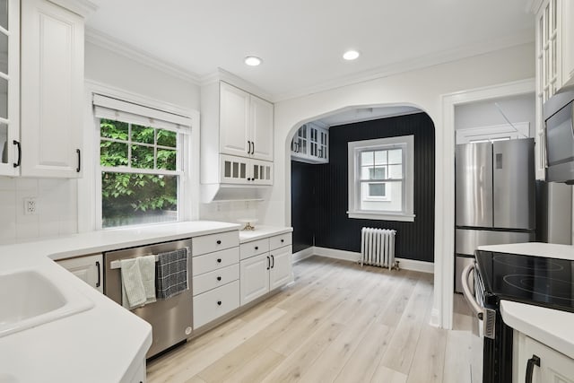 4848 Ewing Ave S, Minneapolis, MN 55410 - kitchen with radiator, appliances with stainless steel finishes, white cabinets, ornamental molding, and decorative backsplash