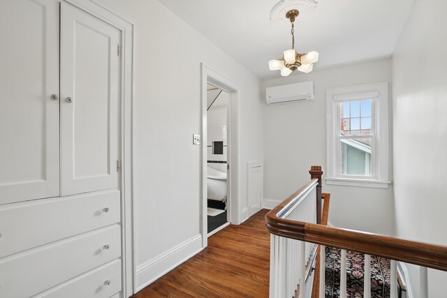 4848 Ewing Ave S, Minneapolis, MN 55410 - hallway featuring an AC wall unit, an upstairs landing, a chandelier, baseboards, and dark wood-type flooring