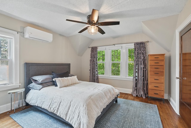 4848 Ewing Ave S, Minneapolis, MN 55410 - bedroom with an AC wall unit, multiple windows, baseboards, a textured ceiling, and vaulted ceiling