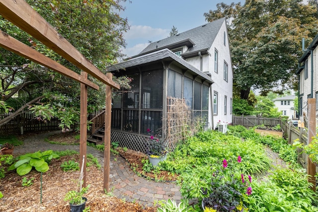 4848 Ewing Ave S, Minneapolis, MN 55410 - view of side of property with a sunroom, roof with shingles, stucco siding, and a fenced backyard