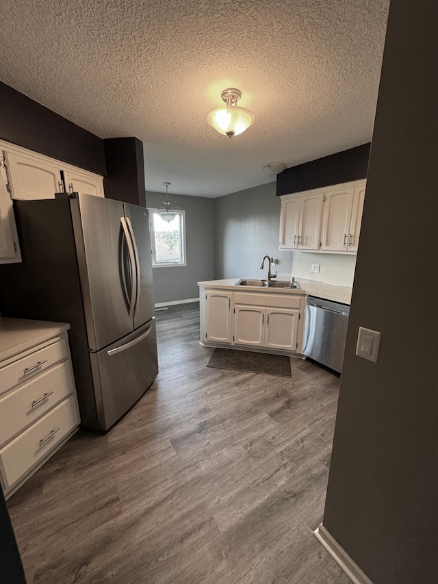 4198 Hilltop Ln, Eagan, MN 55123 - kitchen featuring stainless steel appliances, a sink, white cabinetry, a textured ceiling, and dark wood finished floors