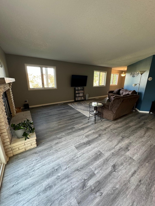 4198 Hilltop Ln, Eagan, MN 55123 - living area with a fireplace with raised hearth, a textured ceiling, wood finished floors, and baseboards
