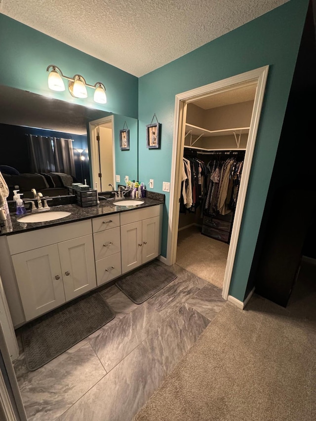 4198 Hilltop Ln, Eagan, MN 55123 - full bathroom featuring double vanity, a textured ceiling, and a walk in closet