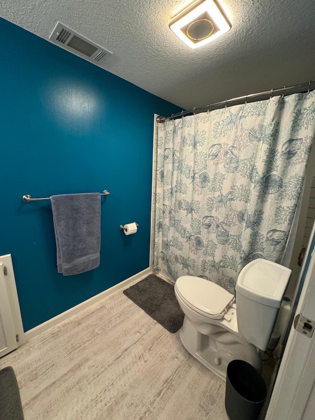 4198 Hilltop Ln, Eagan, MN 55123 - full bath with wood finished floors, toilet, a textured ceiling, and a shower with shower curtain