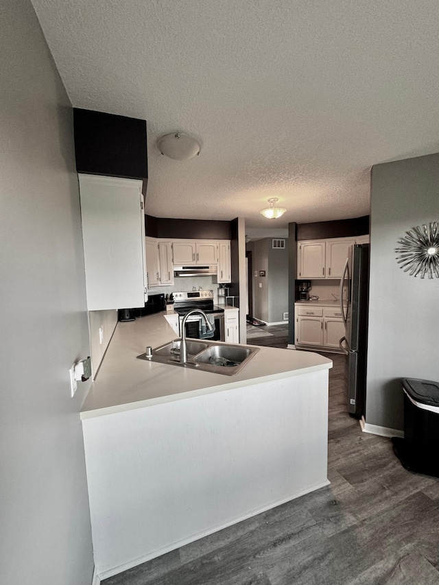4198 Hilltop Ln, Eagan, MN 55123 - kitchen featuring appliances with stainless steel finishes, a peninsula, dark wood-style flooring, a textured ceiling, and under cabinet range hood