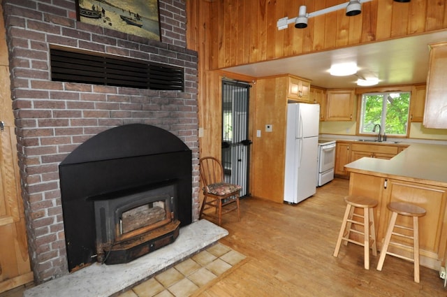 24892 277th Ave, Akeley Twp, MN 56467 - kitchen featuring white appliances, light wood-style floors, light countertops, light brown cabinetry, and a wood stove